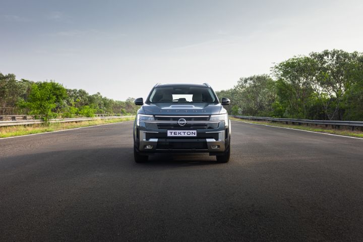 Front view of the Nissan Tekton positioned on an open road, showcasing its wide grille and distinctive lighting signature.