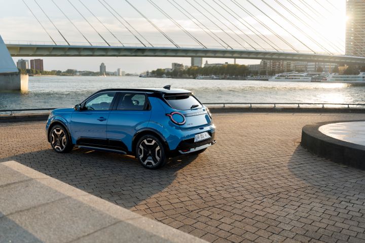 3/4 Heckansicht eines blauen Nissan Micra, der im Sonnenuntergang an einem städtischen Ufer in Rotterdam steht