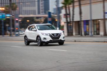 Image floue d'un Nissan Qashqai blanc roulant sur la route en direction de la caméra