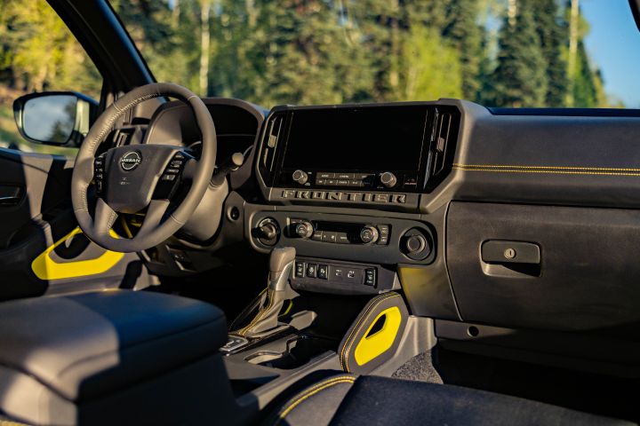 The steering wheel, dashboard and dashboard display inside the 2027 Nissan Frontier Sport Edition.