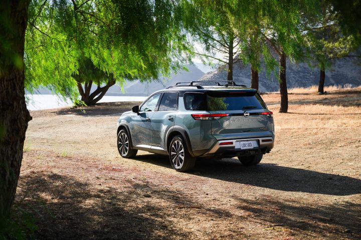 Left 3/4 rear view of the 2026 Nissan Pathfinder parked under a willow tree.