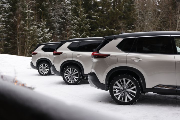 Heckansicht von drei silbernen Nissan X‑Trail e‑Power e‑4ORCE im Schnee