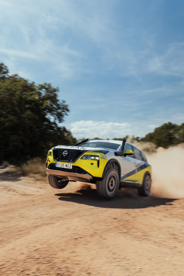Der Nissan X‑Trail Rennwagen springt über eine Unebenheit in der sandigen Rallyepiste während der Baja Aragon Rallye 2024 und zieht eine Staubfahne hinter sich her