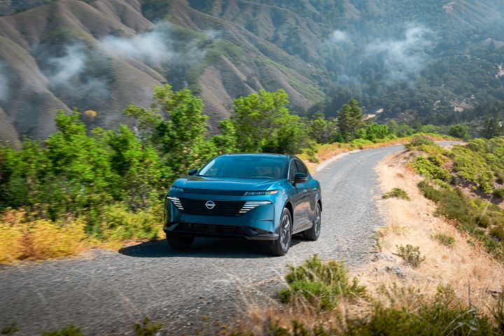 The 2026 Nissan Murano driving along a cliff pathway with mountains and tropical landscaping behind.