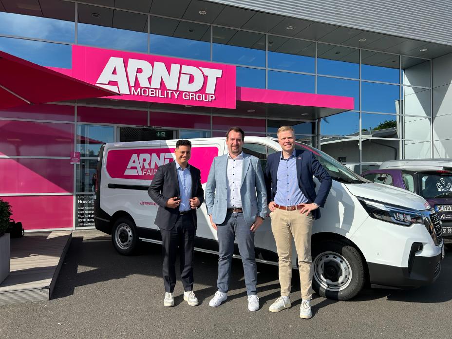 Drei Männer stehen vor einem Nissan Primastar, der wiederum vor einem Gebäude mit der großen Aufschrift Automobile Arndt geparkt ist