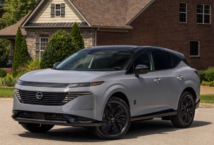 Front left 3/4 view of the 2027 Nissan Murano Dark Armor parked in front of a residential house.