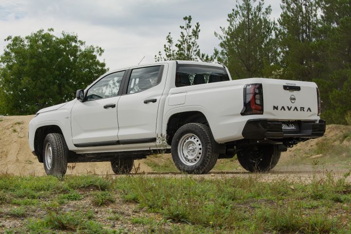 Rear angled shot of a 2026 Nissan Navara in Alpine White paint.