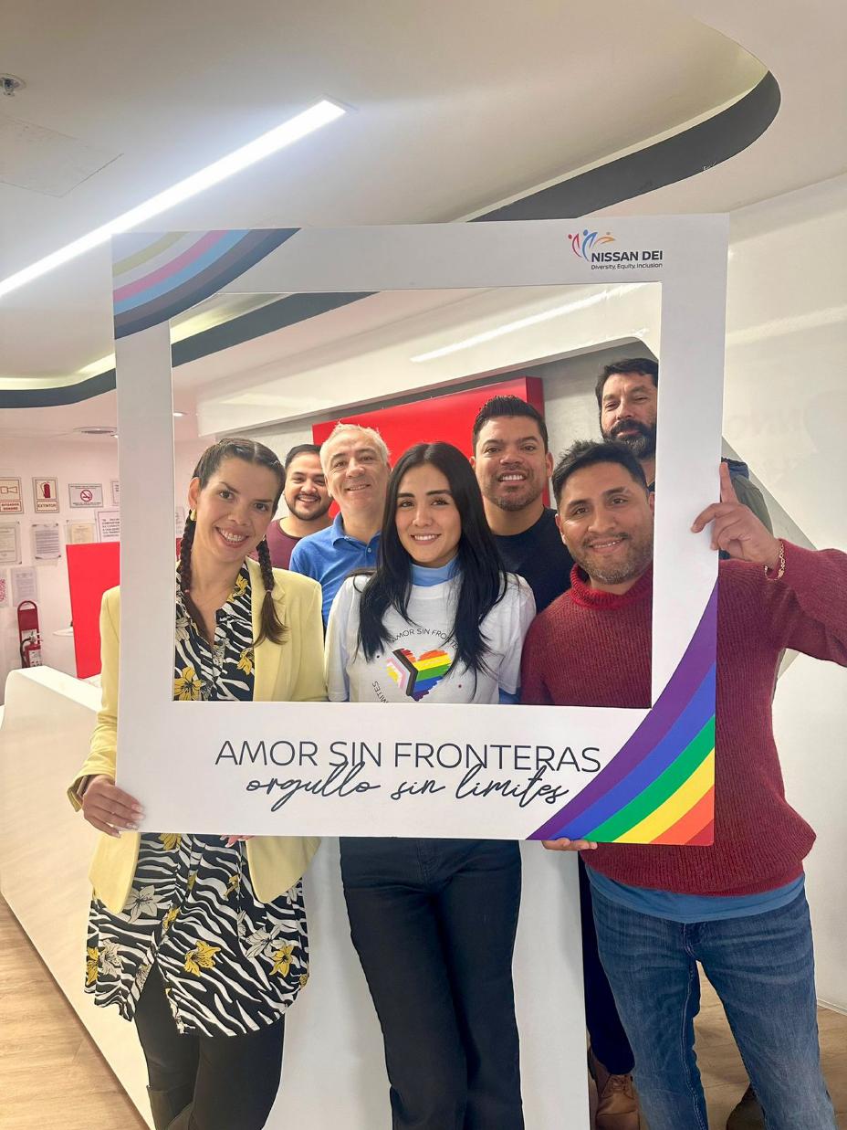 Um grupo de funcionários da Nissan segurando uma moldura que diz “Amor sem fronteras, orgulho sem limites”