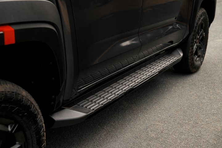2026 Nissan Navara PRO-4X finished in Boulder Grey showing the side step, textured step surface, black sill trim and lower door contour.