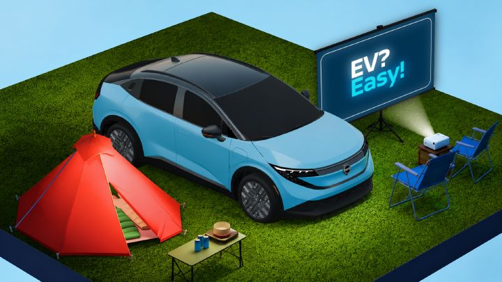 Ein blauer Nissan-Elektro-SUV auf einem Campingplatz mit einem roten Zelt, einem Picknicktisch, Klappstühlen und einem Projektor, der auf einer Leinwand im Freien den Schriftzug „EV? Easy!“ anzeigt