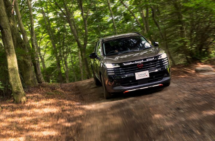 キックス「ROCK CREEK」が、森林の中の未舗装路を走行している。車両はやや右向きのフロントアングルでカーブを走り抜けており、前輪付近から土埃が舞い上がる躍動感のあるシーンとなっている。
