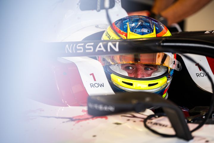 Oliver Rowland sitzt mit seinem gelben Helm und hochgeklapptem Visier im Auto mit der Startnummer 1, kurz bevor er auf die Strecke fährt.