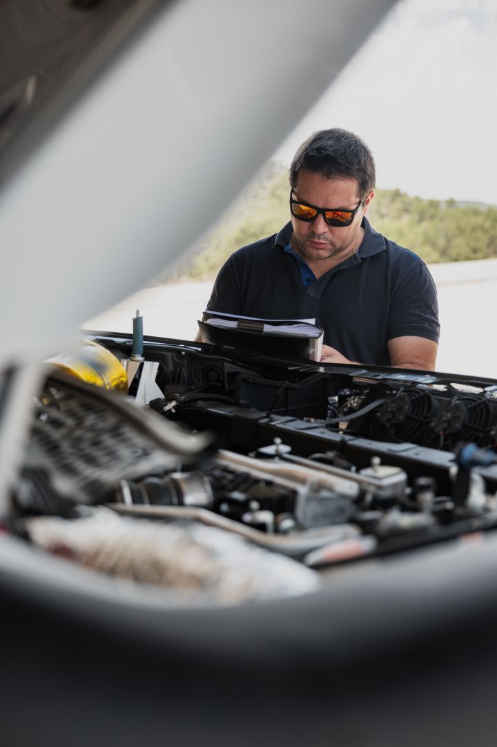 Ein Nissan Ingenieur schaut in den Motorraum des Nissan X‑Trail Rennwagens