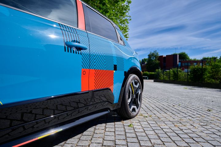 Detailaufnahme des Nissan Micra Signature Edition Gewinnerfahrzeugs, linke Fahrzeugflanke mit blauer Grundlackierung und grafischen Elementen in rot, weiß, schwarz und gelb.