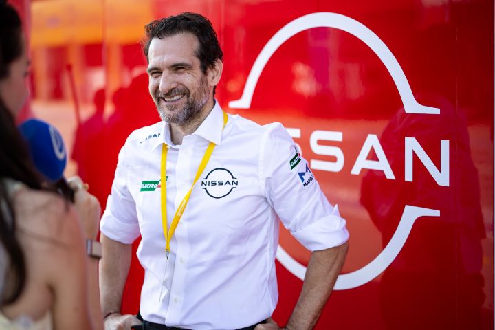 Tommaso Volpe gibt ein Interview in seinem weißen Team-Shirt mit einer roten Wand und weißem Nissan-Logo im Hintergrund.