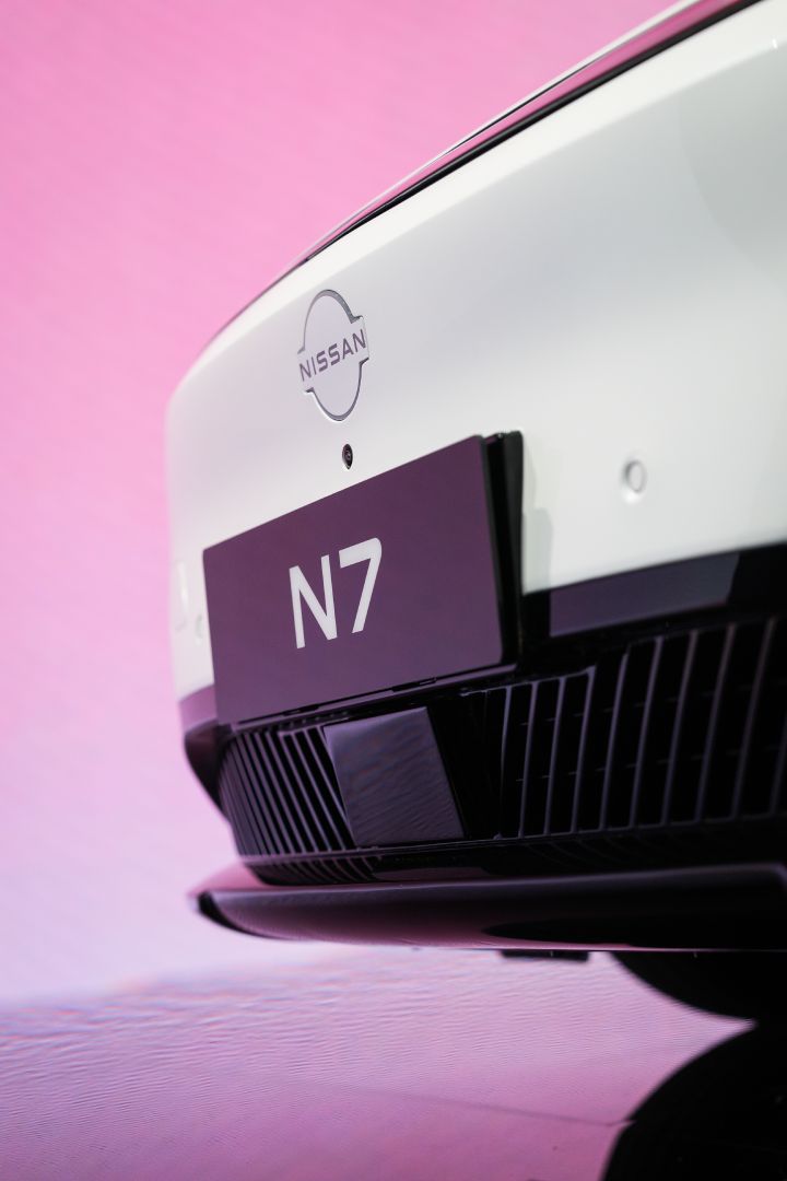 日産バッジ、フロントカメラ、N7 ネームプレートにフォーカスした東風日産の白い新型セダン電気自動車「N7」のクローズアップ。