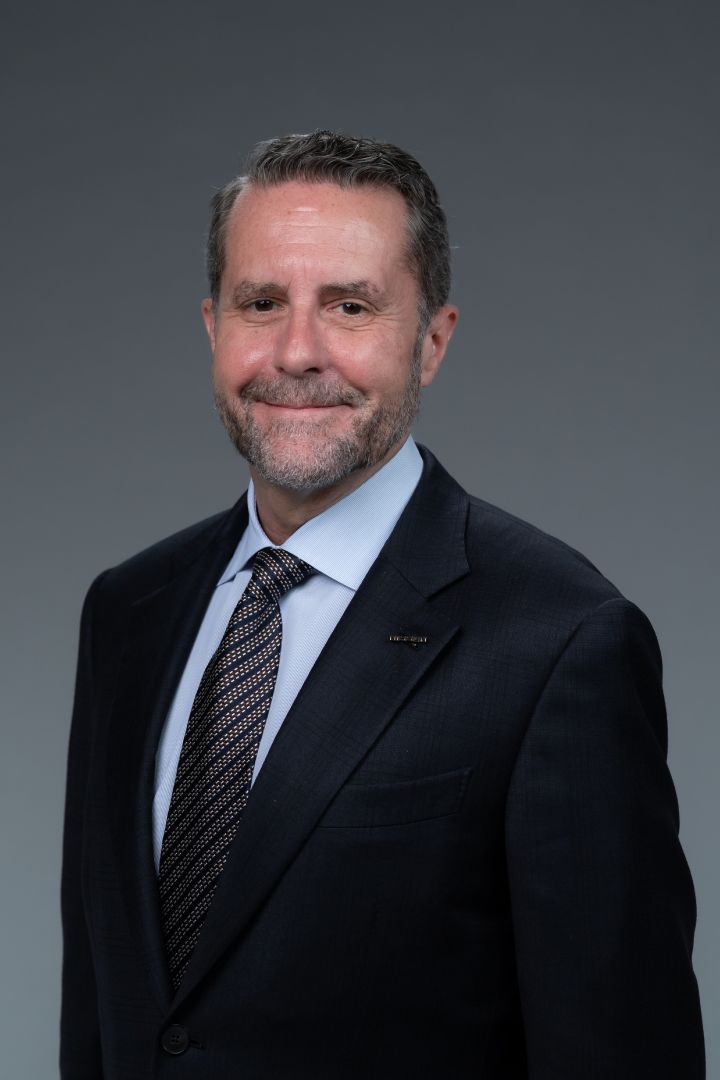 Portrait of Andrew House (suit, tie, NISSAN corporate pin)