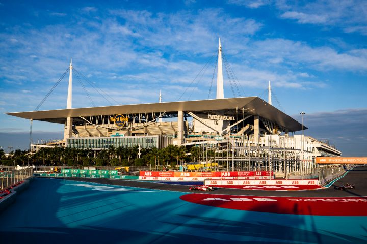 Blick auf das sonnenbeschienene Hard Rock Stadion an der Rennstrecke von Miami, davor ist klein der Nissan Formula E Rennwagen von Norman Nato zu sehen