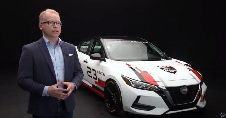 Steve Milette talking in front of a Sentra Cup car.