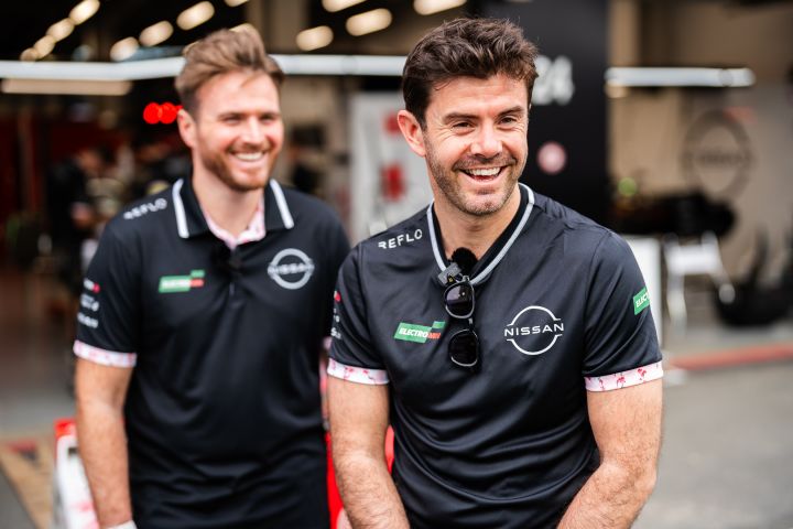 Norman Nato und Oliver Rowland lächeln beide in der Formel E Boxengasse, Nato im schwarzen Nissan Team-Shirt und Rowland im schwarzen Nissan Poloshirt.