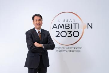 Makoto Uchida standing in front of a Nissan Ambition 2030 sign.