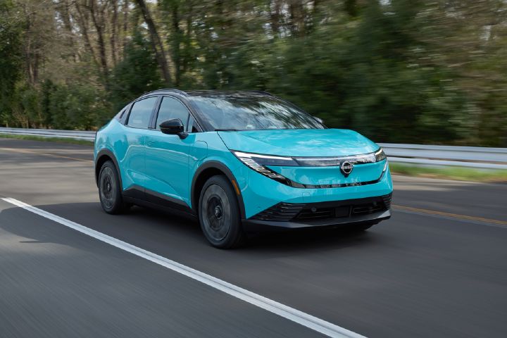 Front right ¾ view of the 2026 Nissan LEAF driving along a main road.
