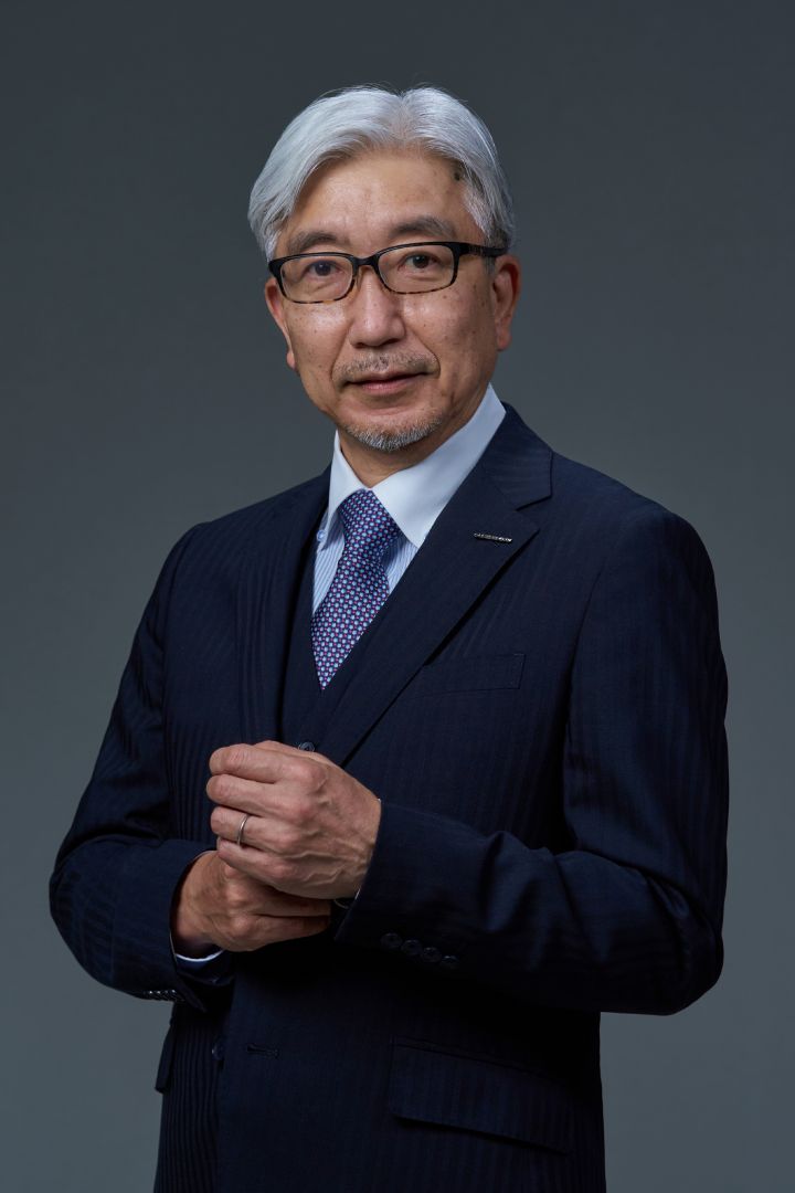 Portrait of Mitsuro Antoku clasping his hands (suit, tie and NISSAN corporate pin)