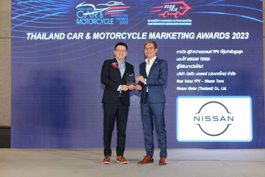 Two men holding an award and shaking hands