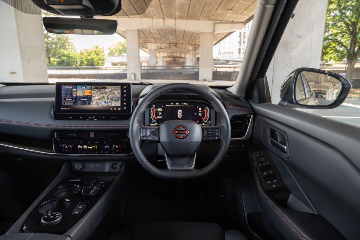 Interior view of the Nissan X‑Trail, featuring the digital driver display, central touchscreen with navigation, multifunction steering wheel, and centre console controls