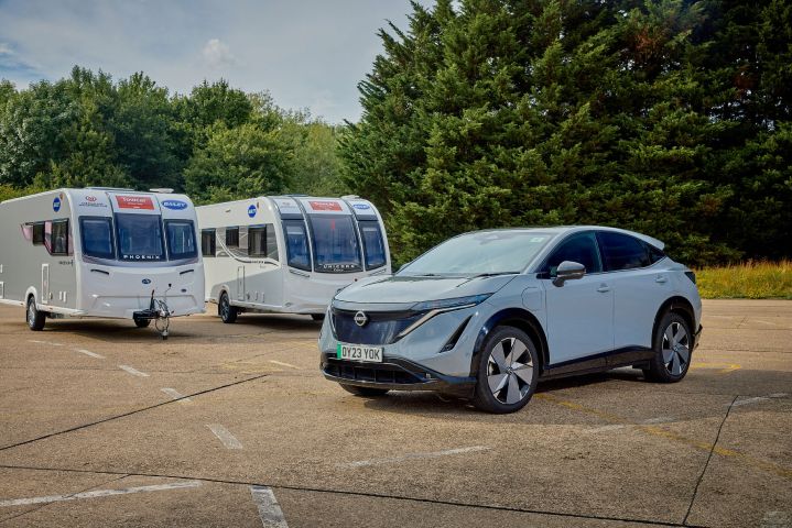 Ariya parked in front of 2 caravans
