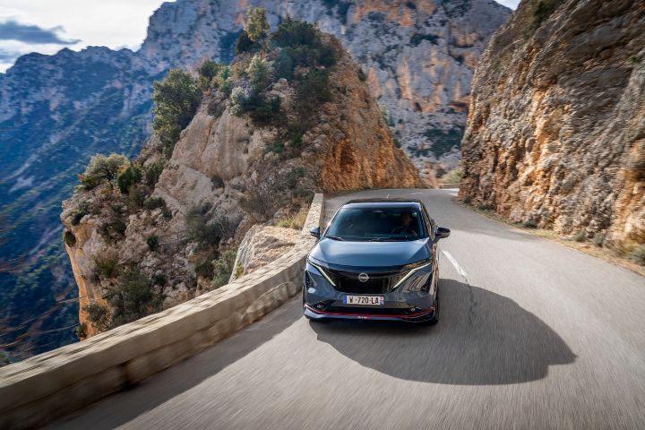 Photo de l’avant de l’Ariya Nismo vu de haut roulant sur des routes de montagne.
