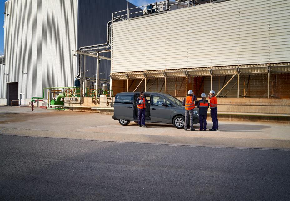 Townstar Crew Van de lejos con tres obreros delante de la misma y uno saliendo de la furgoneta, esta escena se encuentra en medio de una zona industrial
