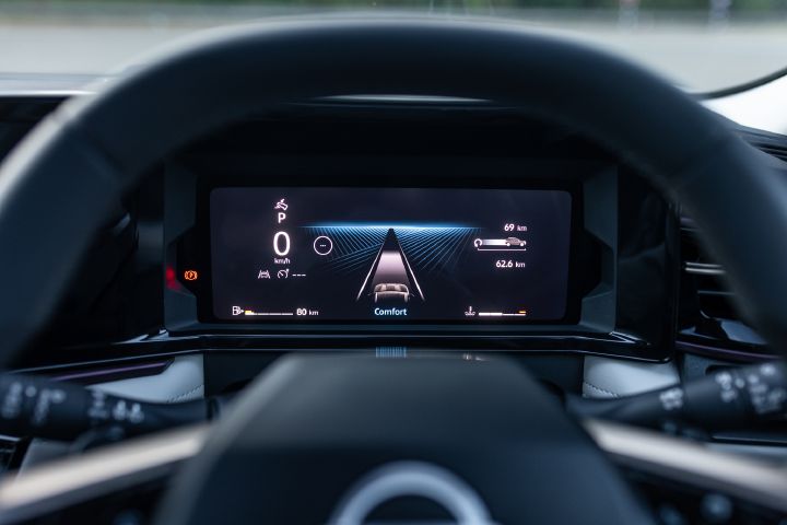 Digital instrument cluster displaying driving information and driver assistance visuals.