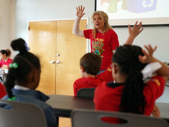 A Nissan employee stands at the head of a class demonstrating movement with her hands.