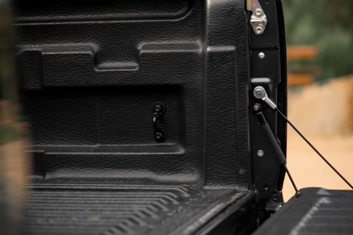 2026 Nissan Navara PRO-4X finished in Boulder Grey highlighting the open tub’s tailgate damper, support cable and textured liner detail.
