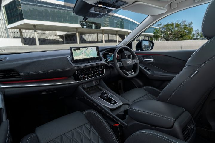 Interior of a Nissan Qashqai showing the dashboard, infotainment display, centre console, steering wheel and front seats