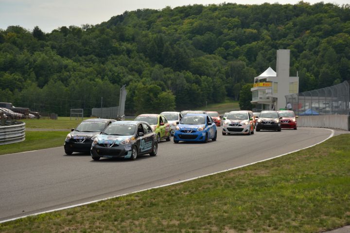 Groupe de voitures de la Coupe Nissan Micra circulant sur la piste.