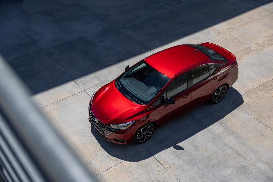 A red 2023 Nissan Versa parked in a parking lot.