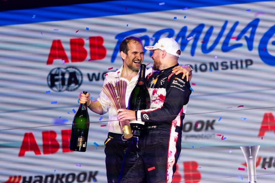 Oliver Rowland en Tommaso Volpe vieren - elkaar omarmend - de winst op het podium van de London E-Prix