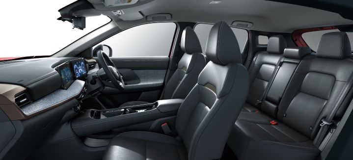 Angled overhead view of the Nissan Kicks interior. Front and rear seats are visible, with the dashboard and center console extending across the cabin.