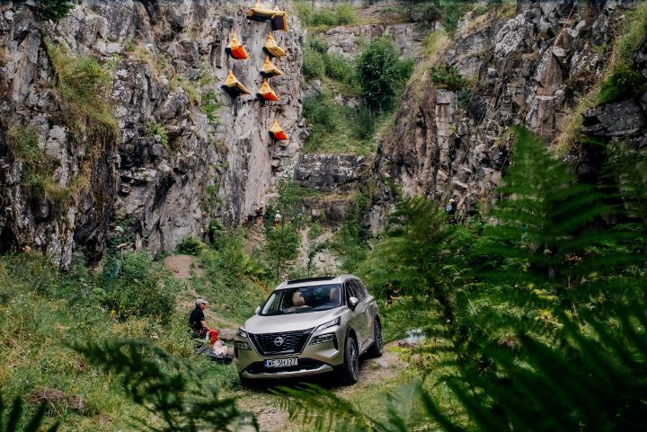 Nissan X‑Trail zaparkowany wśród skał i zieleni podczas wydarzenia outdoorowego