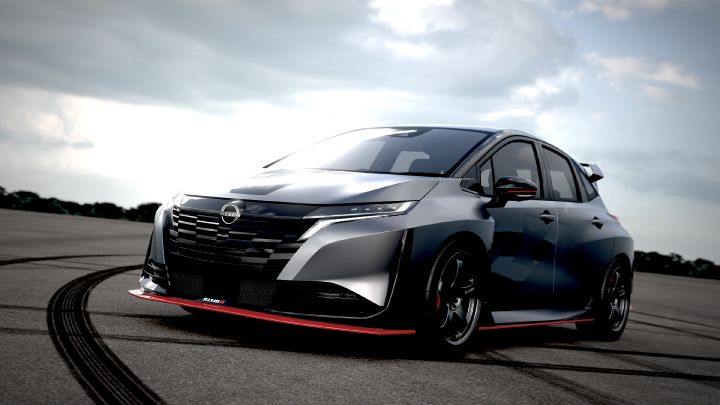 A silver and black two-tone sports car, the Aura Nismo RS Concept, parked on an outdoor skid pad in a front-left angled view. The vehicle features a low stance and a large rear wing, with the Nissan logo on the center of the front grille and a red accent line with the 'NISMO' logo on the lower bumper. The wheels are black with visible red brake calipers, and the side displays a light gray 'RS.' The background shows a cloudy sky and distant trees, with tire marks visible on the asphalt surface."