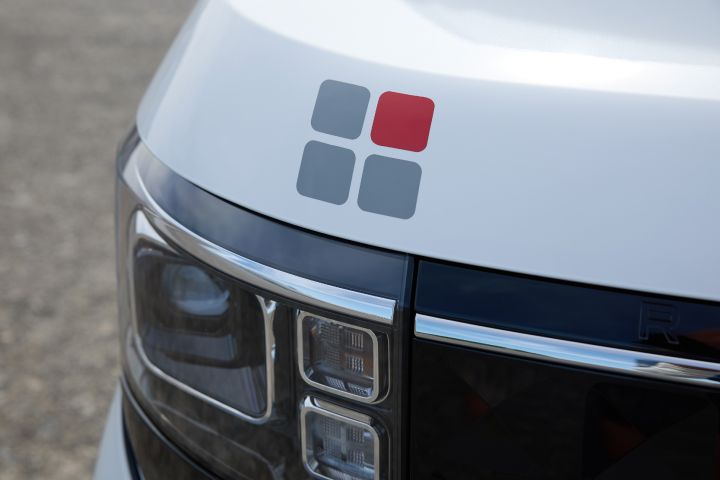 The front section of the new Nissan Roox kei car features a hood decal with a design of gray and red squares.