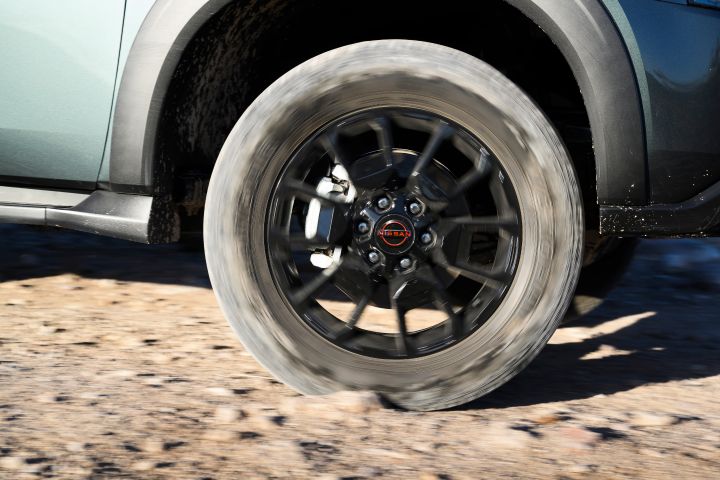 Close up of a 2025 Nissan Armada PRO-4X wheel in driving action on a rocky road.