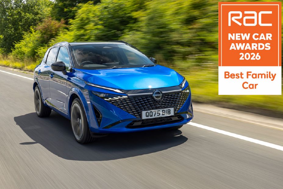 Close up image of a blue Qashqai being driven on a tarmac road with a leafy, green background
