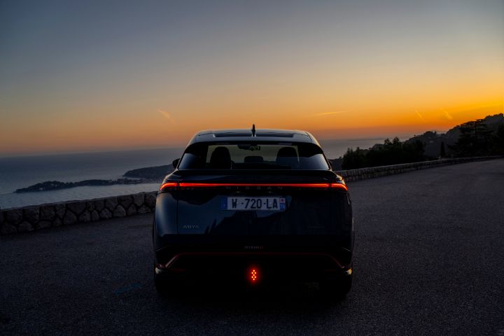 Photo de l’Ariya Nismo vu de derrière faisant face au coucher de Soleil.