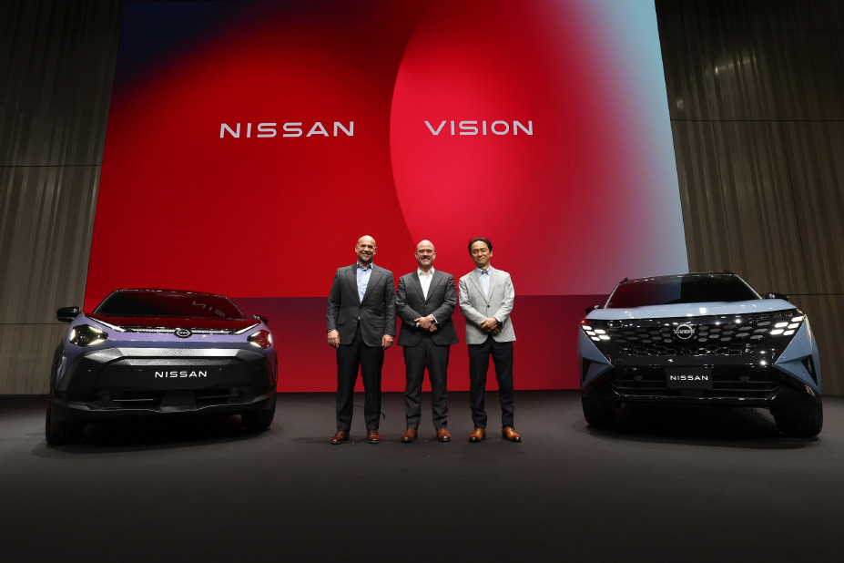 ผู้บริหารยืนบนเวทีหน้าฉาก “Nissan Vision” ระหว่างรถคอนเซ็ปต์นิสสันสองคันในงาน