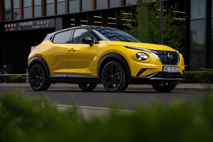 Żółty Nissan Juke stojący bokiem przed budynkiem