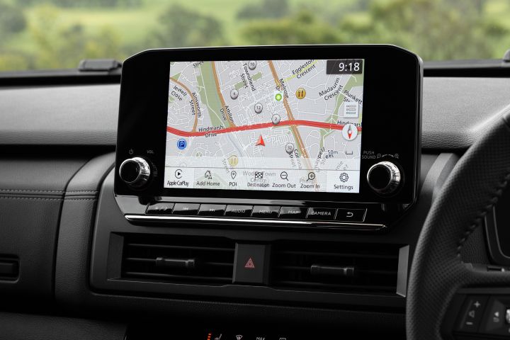 Front dashboard view of a 2026 Nissan Navara ST-X showing the 9-inch Touch infotainment screen displaying a navigation map, with physical shortcut buttons, air vents, and the upper dashboard in view.
