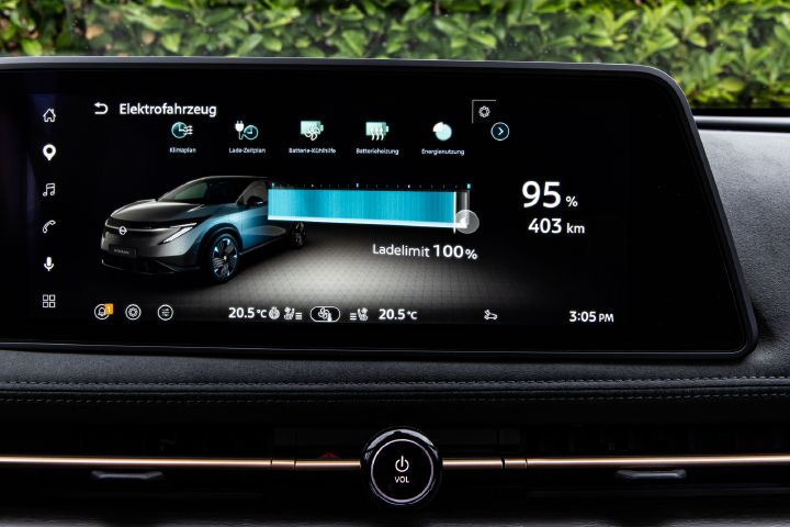 Innenraum des Nissan Ariya mit Detailansicht auf den Infotainmentbildschirm, der den Ladestatus anzeigt